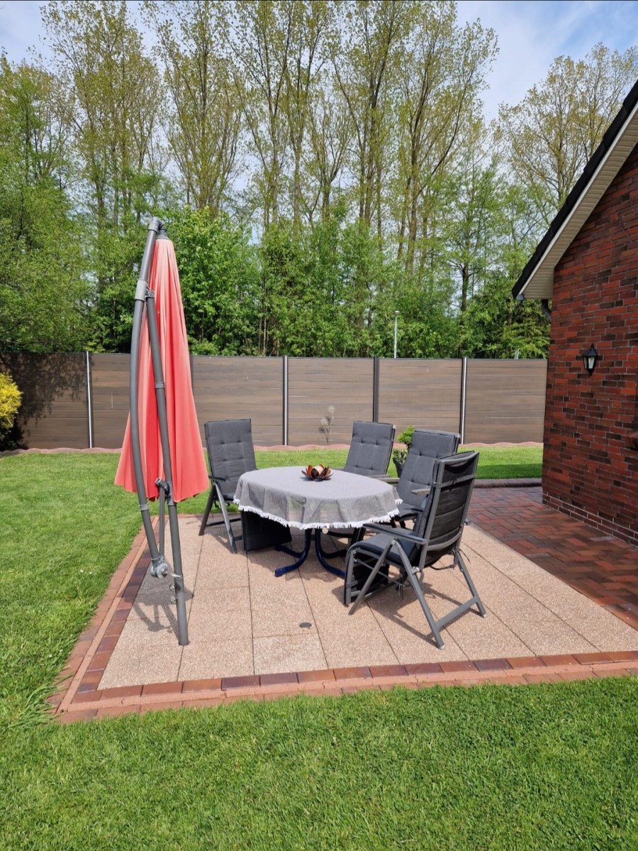 Terrasse mit Sonnenschirm und Gartenmöbeln